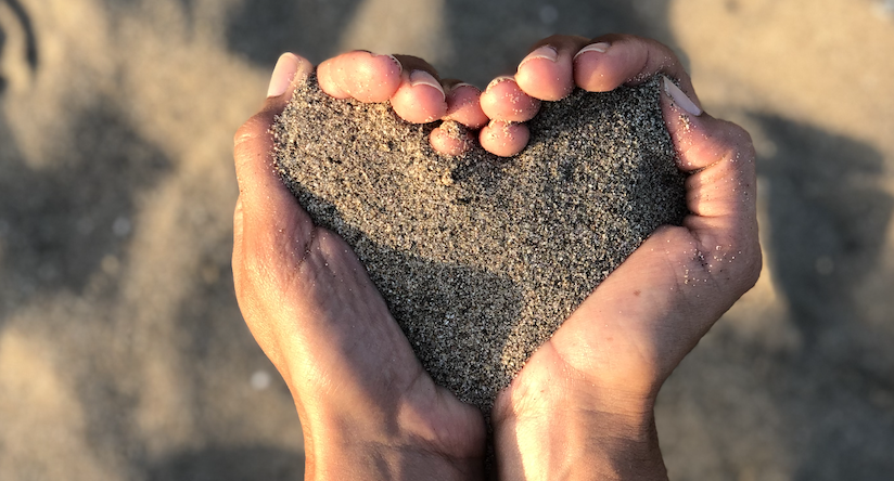 Manos en forma de corazón sosteniendo arena, simbolizando cuidado y calma. Imagen representativa del programa Serena-MENTE de bienestar emocional en Pamplona y Navarra con Sandra López, coach emocional.